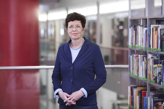 Porträt Dr. Sabine Homilius Foto von Dr. Sabine Homilius zwischen Bücherregalen